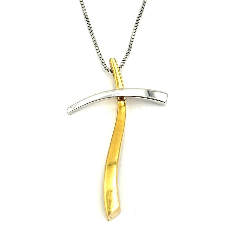 Two-tone gold cross pendant, with chain; 5.87 gr.: Modern cross necklace in 18kt white and yellow gold with an asymmetrical, contemporary design. The pendant combines curved and slender lines, creating an elegant balance between the two colors of