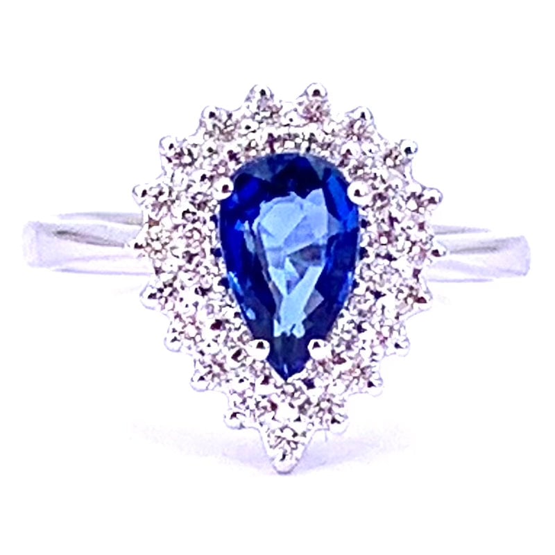 Sapphire drop ring and double round brilliants; 4.16gr: White gold ring with a refined and timeless design. It features a teardrop-cut blue sapphire surrounded by a double circle of diamonds that enhance its intensity. Perfect for adding a sophisticated to