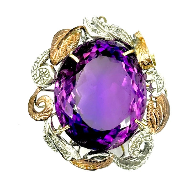 Hydrothermal amethyst maxi-style pendant, gold and silver; 17.57 gr.: A scenic maxi-style pendant made of 9kt gold and sterling silver, with large central hydrothermal amethyst and antiqued scrollwork frame and perimeter foliage! Our company's certification is available
