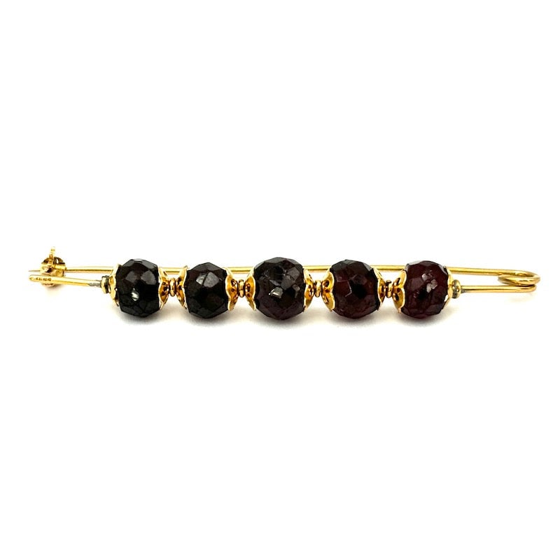 Vintage garnet and yellow gold safety pin; 6.4 cm - 6.06 gr.: Vintage, safety pin-like, elongated classic model in yellow gold, with faceted boules of old garnets. 1950s era. The unmistakable style of yesteryear that will never fade. Our company's certification 