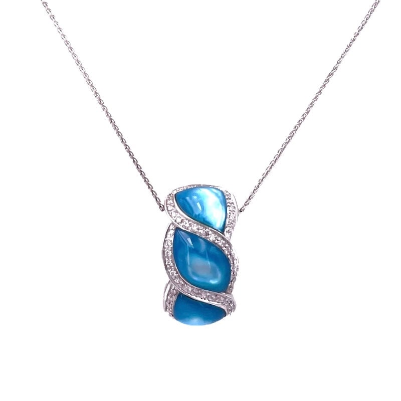 Blue mother of pearl, brilliants and white gold pendant; 12.48 gr.: Intense, unusual and azure! Significant pendant in solid 18 kt white gold, with blue mother-of-pearl (reinforced in color) shaped around bright serpentine brilliants! White gold chain included. Our co