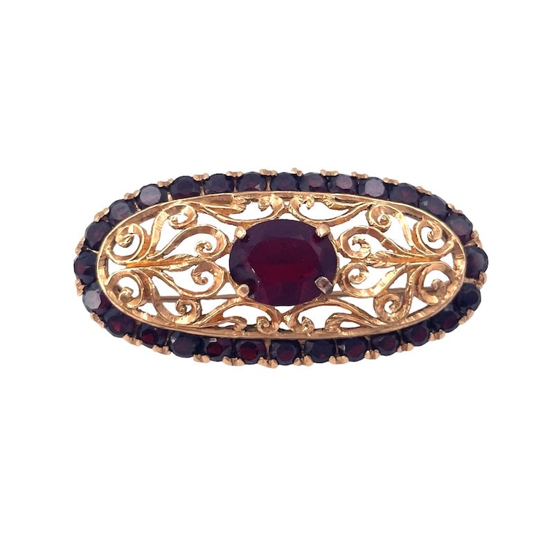 Vintage garnet oval brooch, pierced gold; 10.4 gr.: Enchanting vintage rounded oval brooch in masterfully pierced 18 kt yellow gold with beautiful retro garnets. A true little work of goldsmith's art, a jewel still a stylish accessory with a value and 