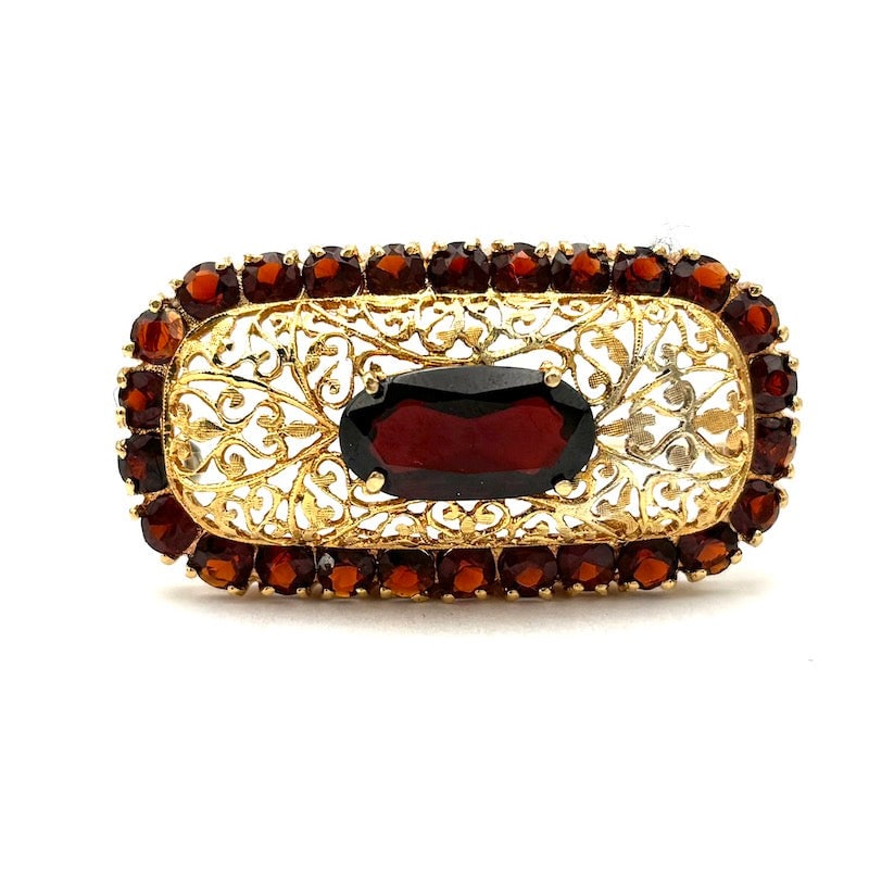 Vintage garnet brooch, rectangular, pierced gold; 9.7 gr.: Enchanting vintage rectangular rounded brooch, 18 kt yellow gold, masterfully pierced, with beautiful retro garnets. A true little work of goldsmith's art, a jewel still a stylish accessory with a val