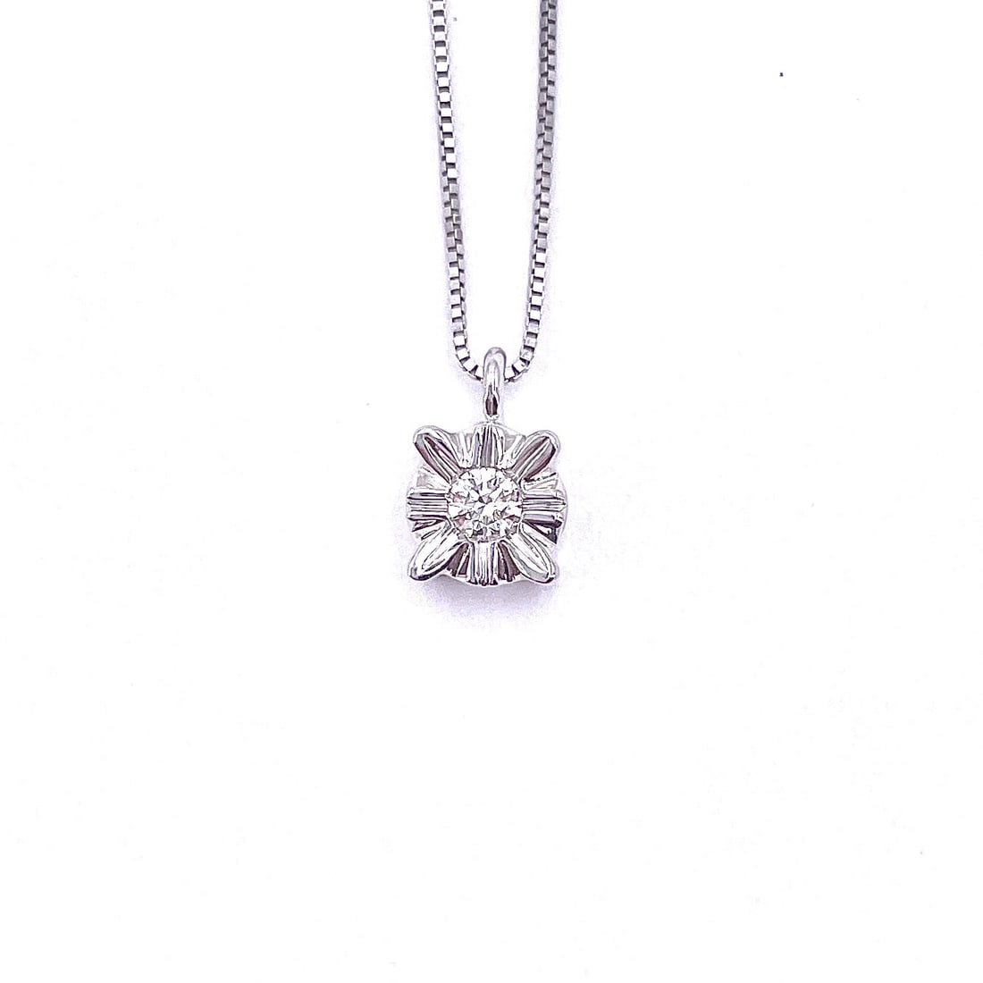"Sly" point light pendant, brilliant and gold - 0.10 ct; 2.48 gr.: Very cute so-called "cunning" light pendant point by virtue of the setting designed to create a larger size effect of the center stone. In 18 kt white gold, with 0.10 ct solitaire brilliant-cut diamon