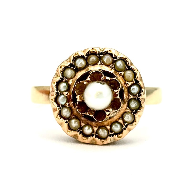 Vintage micropearl and gold ring; 3.49 gr: Delicate, romantic antique ring from the early 1900s in yellow gold. At the center, a small pearl shines, surrounded by other micropearls set in a refined patch setting. The design evokes elegance and