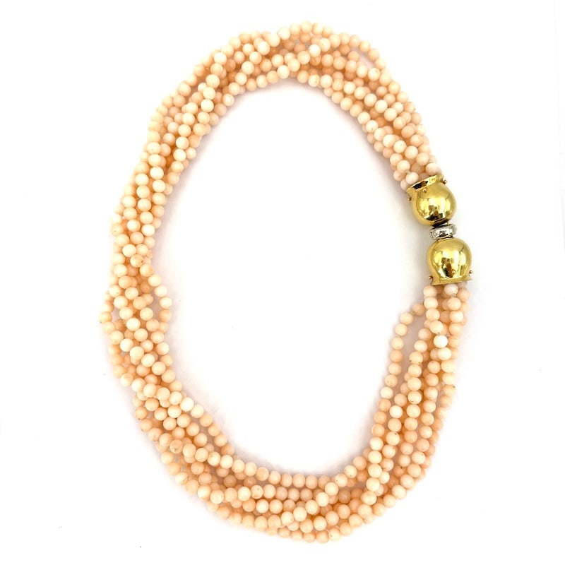 7-strand pink coral and gold torchon necklace - 113.7 gr: Romantic and sophisticated torchon choker necklace composed of 6 strands of imperfect natural pink coral, micro-spherical cut, smooth, 4.5 mm in diameter, with a large bell-shaped clasp in 18 kt yello