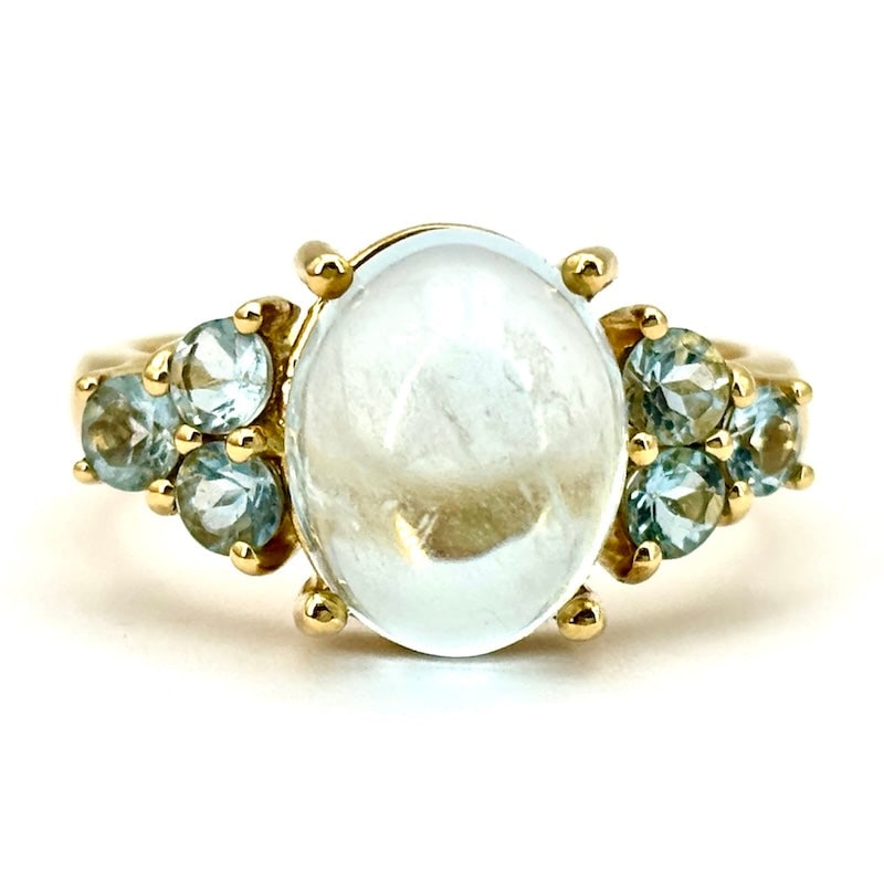 Oval aquamarine ring, with aquamarine triptychs, in yellow gold; 6.64 gr: A very refined, very blue, precious and graceful touch of celestial class on 18 kt yellow gold! Ring with central oval cabochon-cut aquamarine and double lateral triptych of aquamarines. A sophisticat