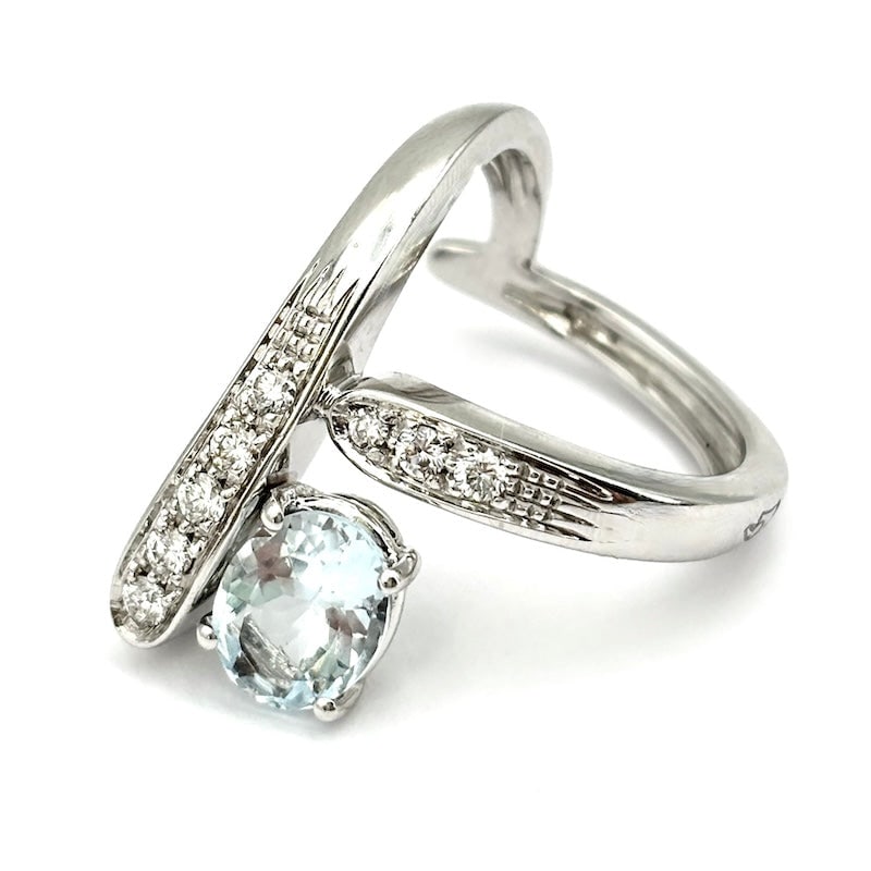 Y-shaped aquamarine and diamond ring in white gold; 9.25 g: A charming and sublime touch of design and azure class! Ring with a fabulous oval-cut aquamarine and diamonds on the Y-shaped front in 18kt white gold. An unusual, second-hand blue jewel of breathtaki