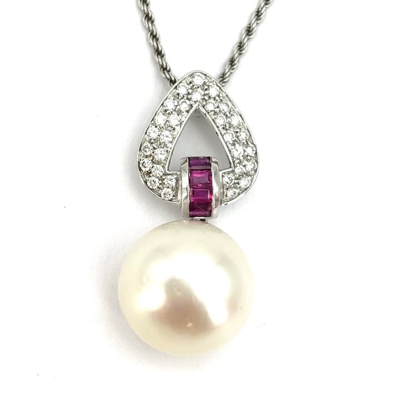 Australian pearl pendant, diamond, ruby, and white gold triangle; 13.19 g: A pure, delicate, and fabulous pendant with a splendid Australian pearl and a white gold triangular setting with a double row of diamonds and a central row of baguette-cut rubies. The timeless eleganc