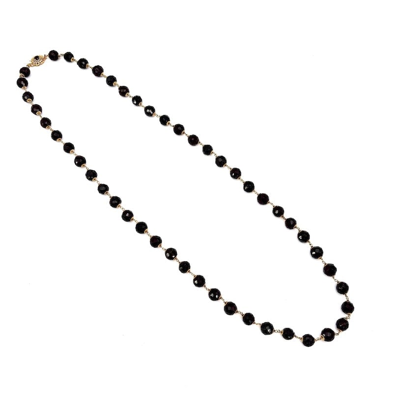 Long vintage necklace, large garnet woven in gold - 80 cm; 128.33 g: Charismatic and essential vintage necklace in retro style, with large irregular faceted garnet spheres intertwined in 18kt yellow gold, with iconic flower caps and a vintage openwork clasp. A stunning