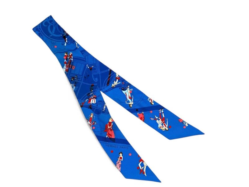 Iconic Hermes Blue Silk Twilly Scarf - Authentic & Perfect: Sophisticated Hermes Twilly crafted from 100% silk featuring refined blue tones. This versatile accessory creates a chic accent when worn on the neck, wrist, or handbag. Presented in perfect condition