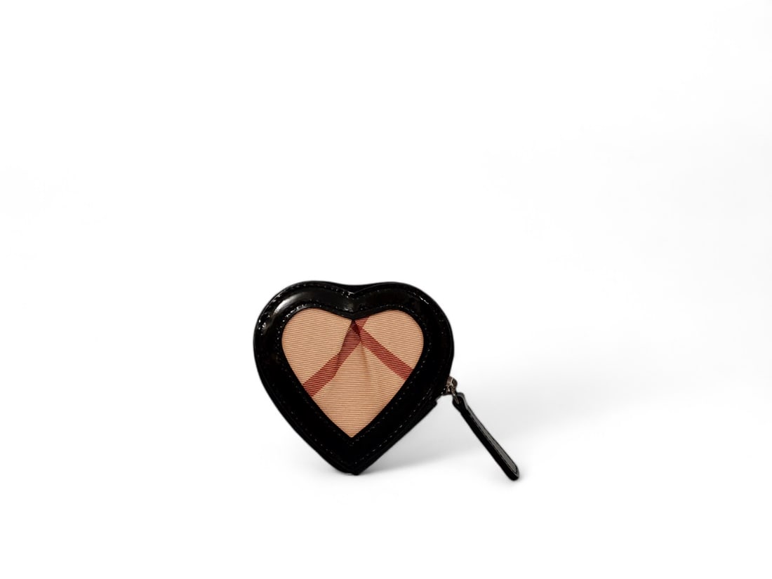 Charming Burberry Heart Coin Purse Canvas & Patent - Authentic: Delightful Burberry heart-shaped coin purse crafted from signature beige canvas with glossy black patent leather trim. Featuring sleek black hardware, this compact accessory combines playful design wi