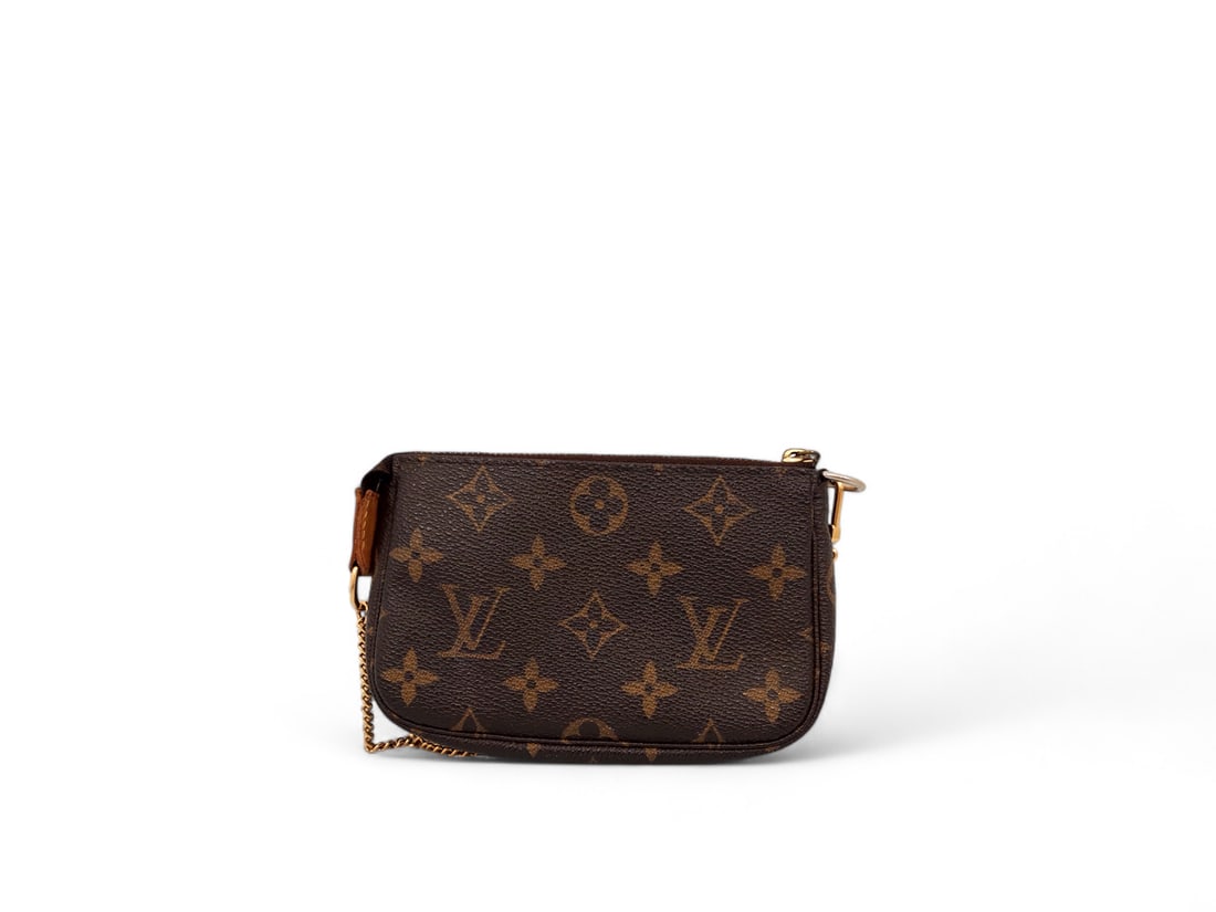 Louis Vuitton Mini Accessoires Monogram Canvas - Iconic & Excellent: Iconic Louis Vuitton Mini Accessoires crafted from the signature Monogram canvas with natural cowhide details. Adorned with glowing gold hardware, this delightful pochette captures the quintessential 