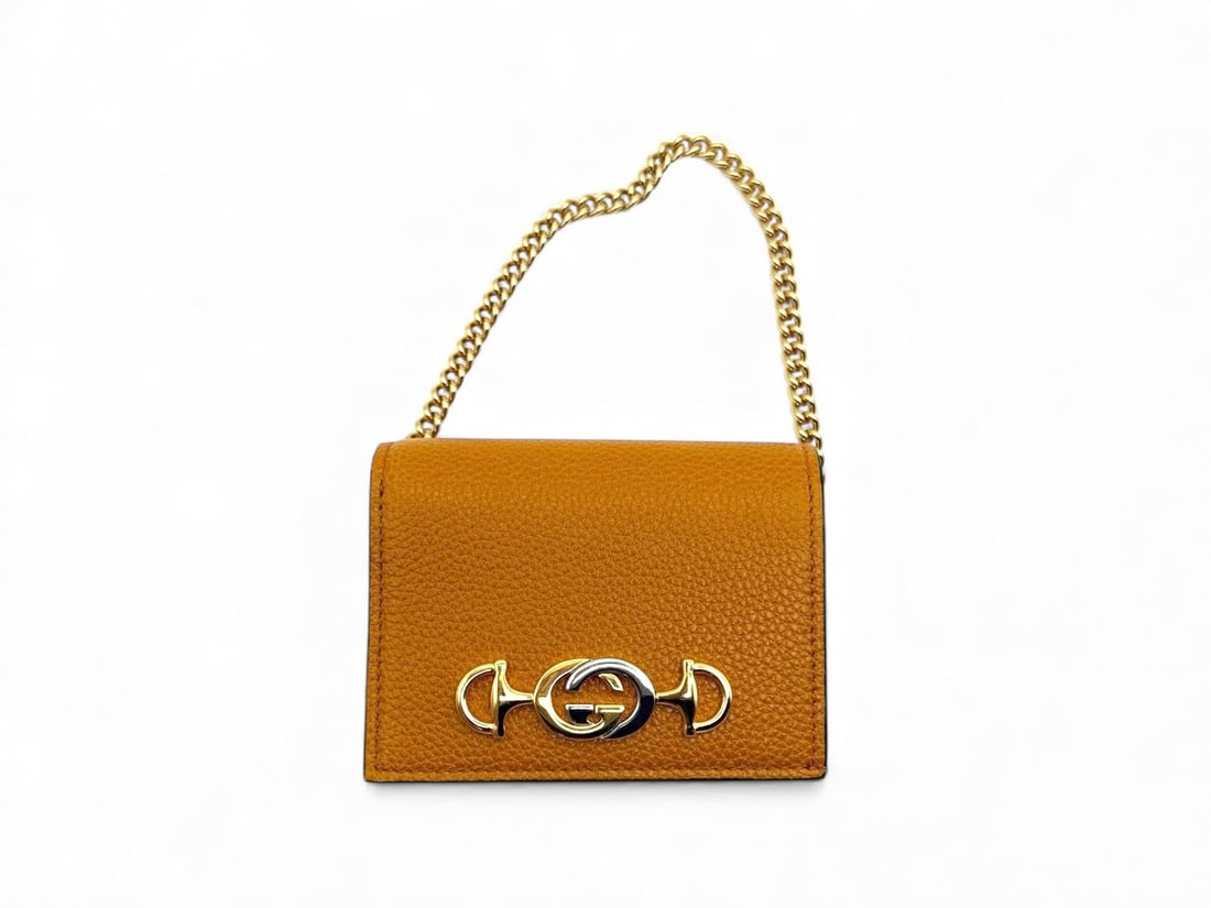 Gucci Orange Leather Zumi Wallet - Vibrant & Exclusive: Radiant Gucci Zumi wallet crafted from premium leather in a bold orange hue. Featuring the signature Interlocking G Horsebit hardware in gold, this accessory is a masterpiece of modern luxury. In perf
