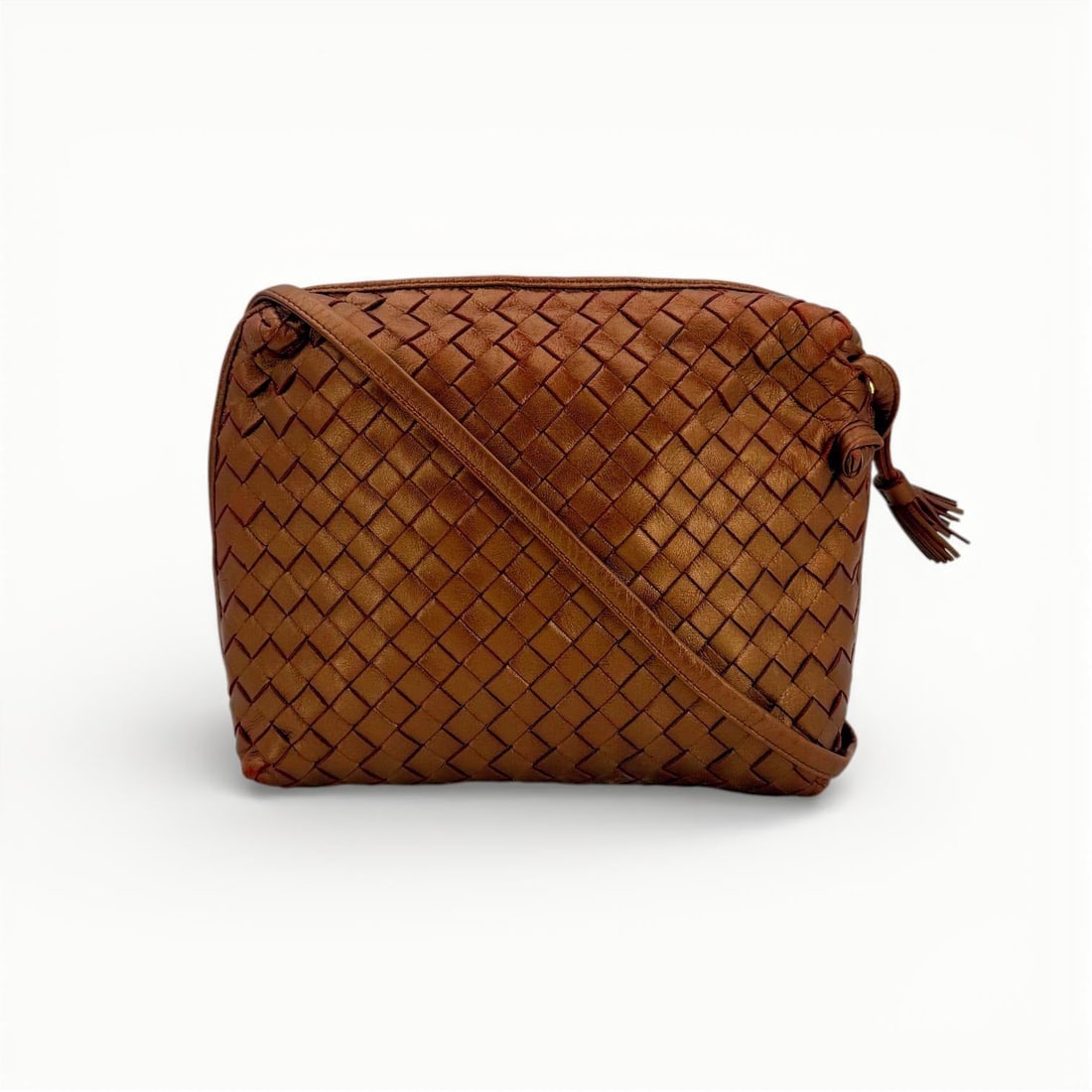 Bottega Veneta Vintage Leather Crossbody Bag Nodini: Embrace the timeless allure of the Bottega Veneta Nodini, a masterpiece of Italian craftsmanship from the 1990s. This small crossbody bag is meticulously crafted from metallic bronze leather, showcasi