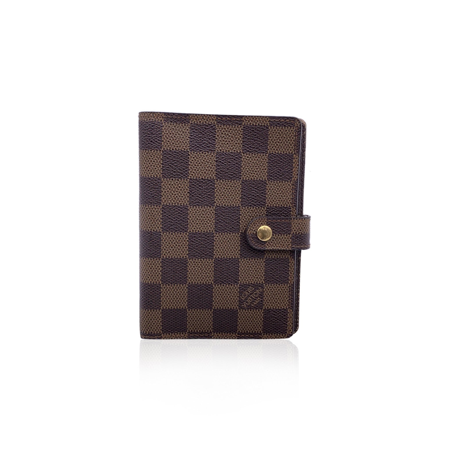 LOUIS VUITTON CLOTH ACCESSORY: Agenda cover in brown Damier canvas by LOUIS VUITTON. Press stud closure. Brown leather interior. Six- Ring binder. 1 pen holder. 3 credit card slots. 2 side sleeve for papers. ity serial number