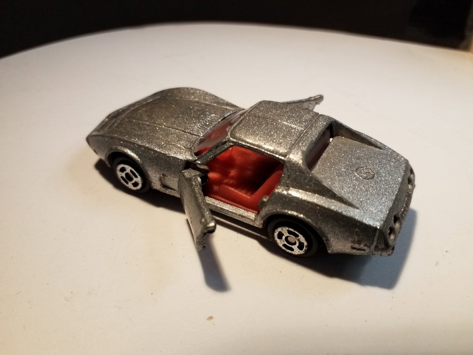 Vintage Speckled Grey Corvettle made in Hong Kong Die cast: both doors open very easily, wheels spin freely, . In Playworn condition. Neat old die cast car