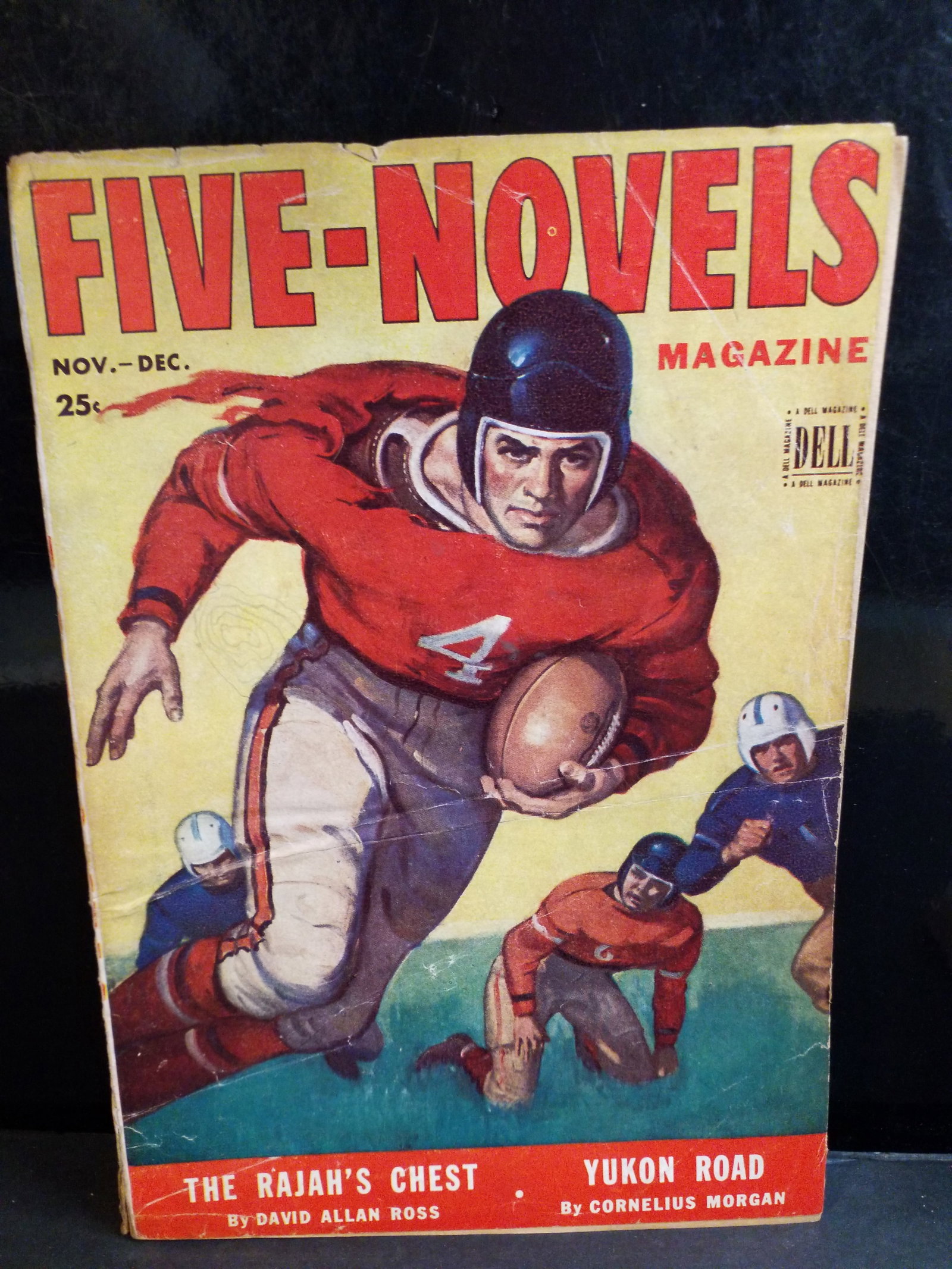 Nov. 1942 Adventure pulp of Five-Novels comics Magazine Sports Football Cover Higher Grade F+: Publisher: Dell Publishing Co., Inc. Cover Theme: Classic vintage college football illustration featuring a running back evasively carrying a leather football. Featured Stories: "The Rajah's Chest" by