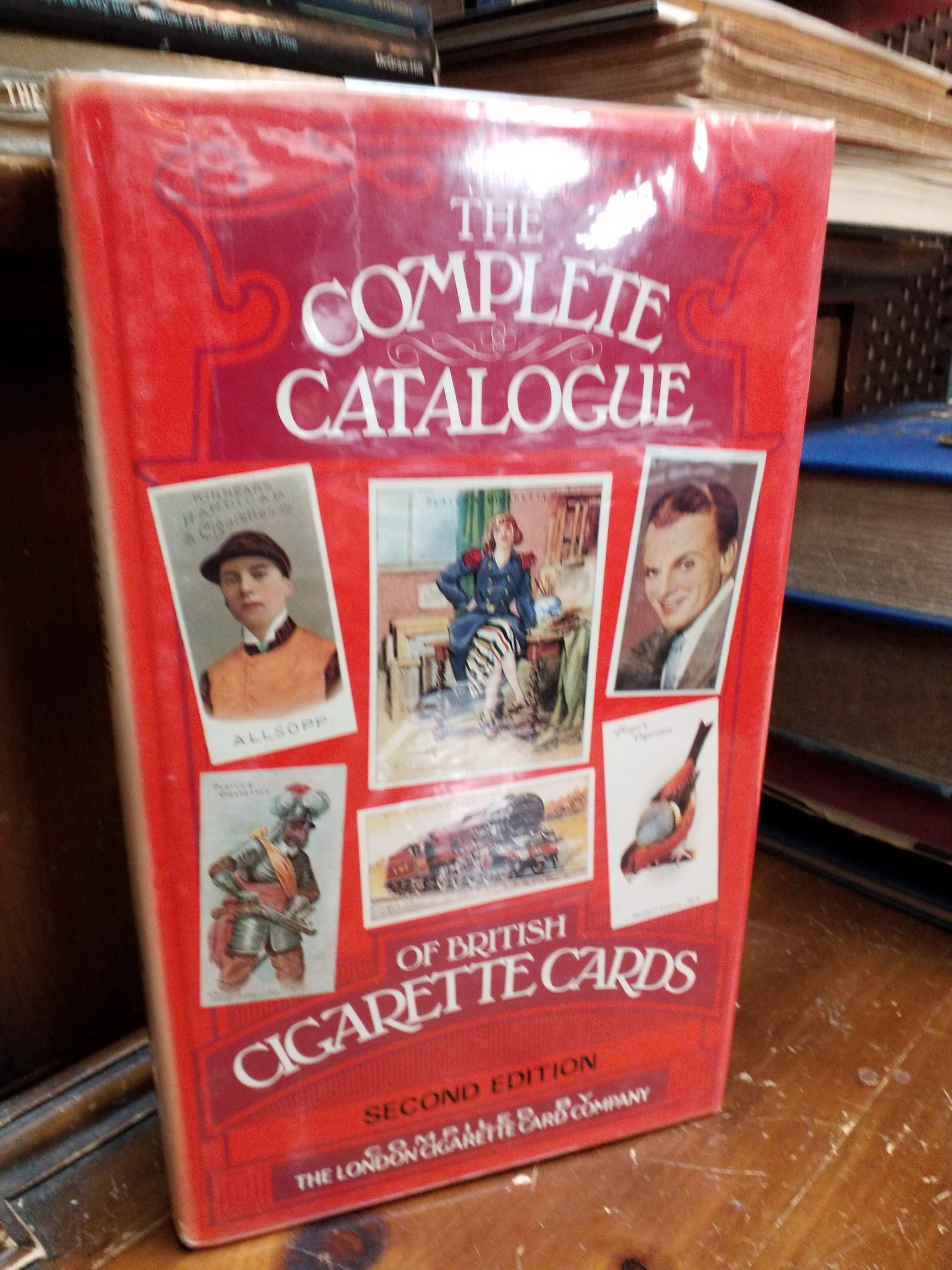 2nd Edition of "The Complete Catalogue of British Cigarette Cards compiled by London Cigarette Co.: This red hardcover is the Second Edition of "The Complete Catalogue of British Cigarette Cards" compiled by The London Cigarette Card Company.The volume covers antique cigarette trading cards and was 