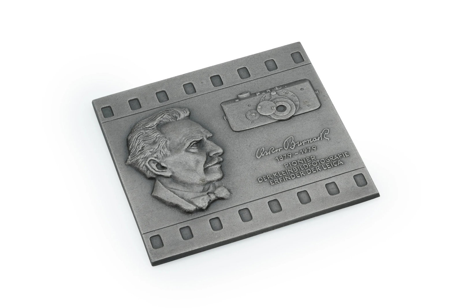 Leica Oskar Barnack Pioneer Metal Plaque: This commemorative metal plaque honors Oskar Barnack, the visionary engineer who developed the first Leica camera. Measuring approximately 7.5x7.5in, the plaque features a detailed relief depicting Ba