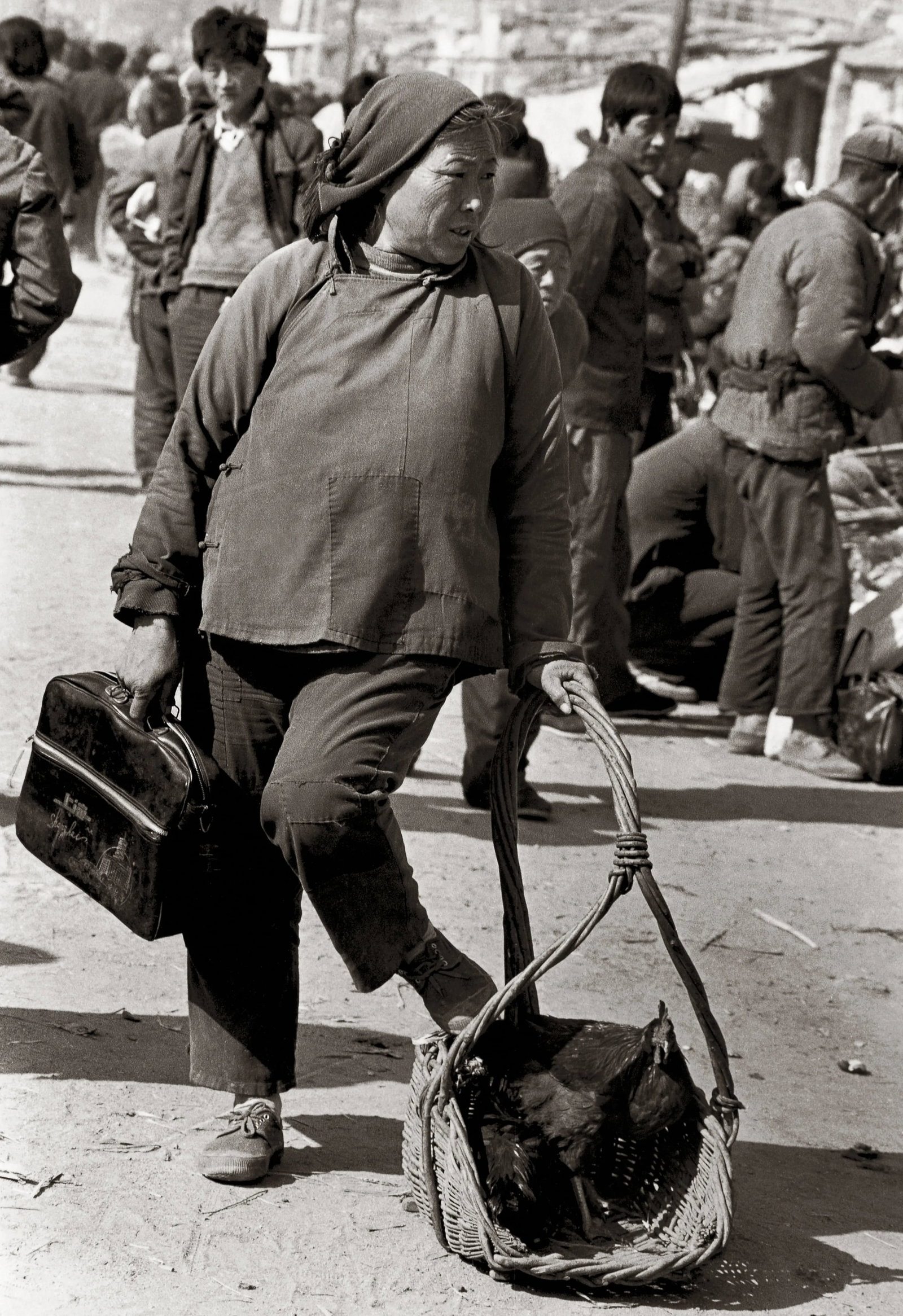 Humanism in China, No. 558: Creation Date: 1988 Location: Linyi, Shandong Technique: Digital giclee print Edition: 1/5 Signature: Signed by the artist Caption: A Yimeng woman carrying a handbag in one hand and a chicken in a