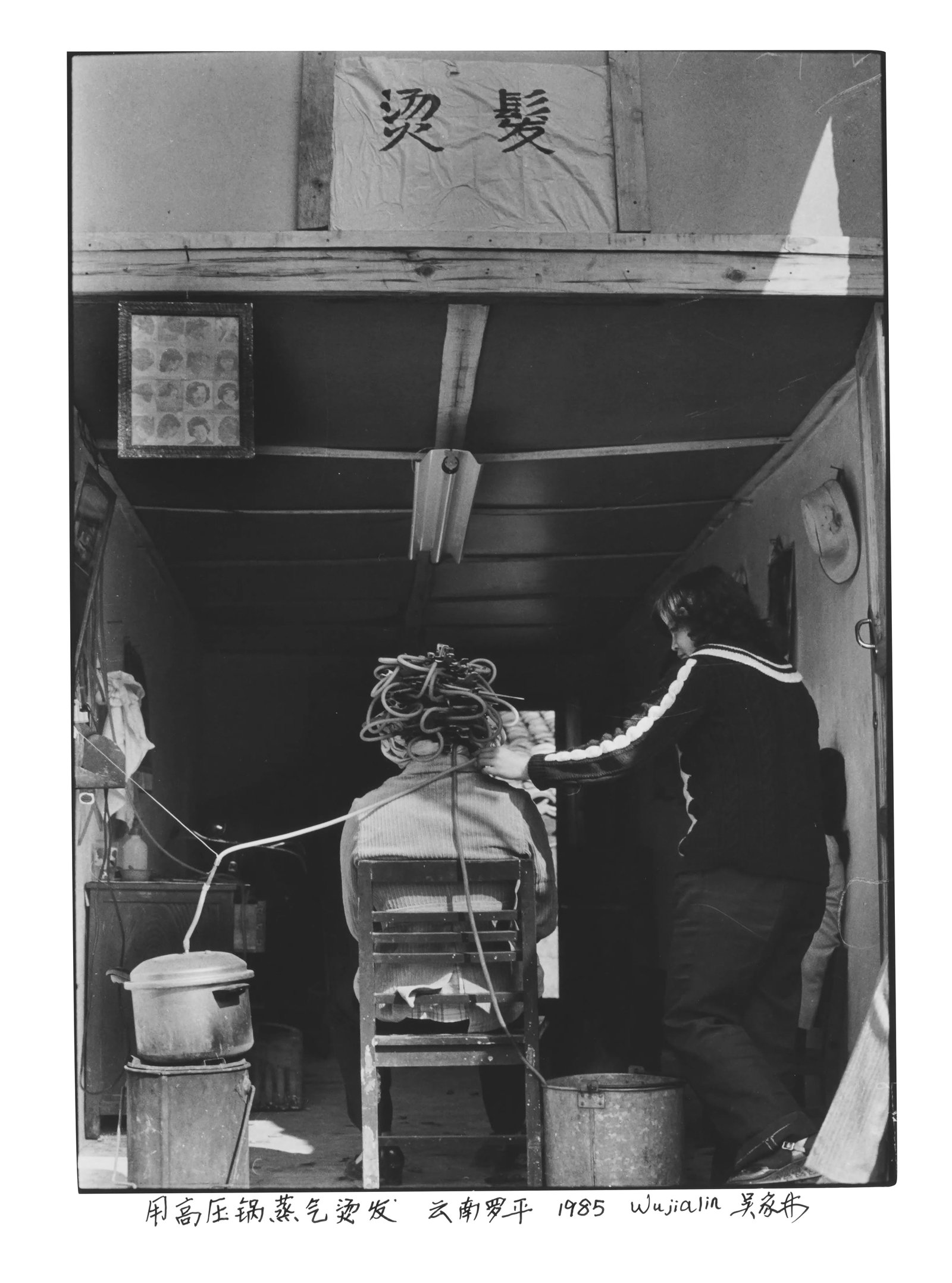 Hair Perm with Pressure-Cooker Steam: Series: Humanism in China, No. 069 Print Date: 2026 Medium: Ilford fiber-based gelatin silver print Edition: Open edition Taken in Luoping, Yunnan, in 1985, this photograph captures a barber using a