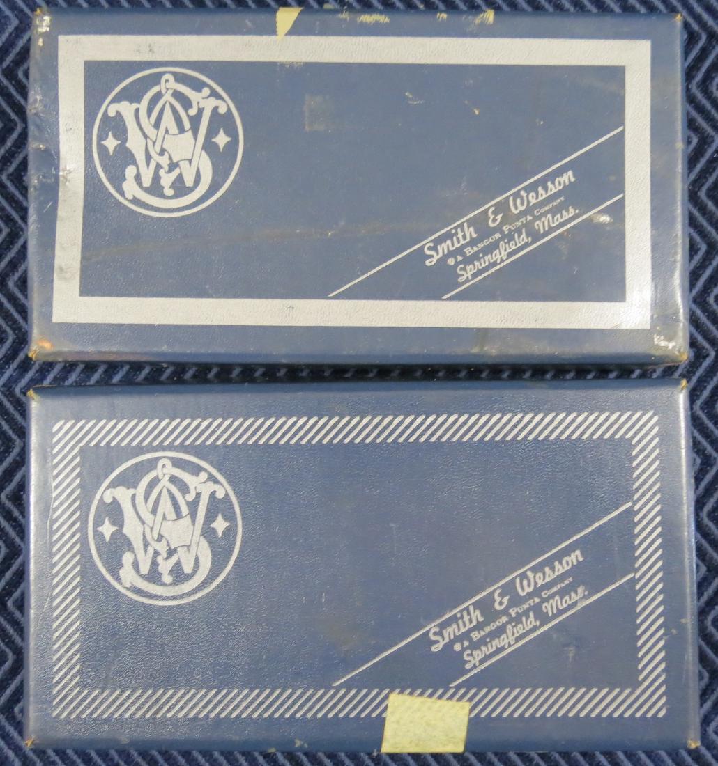 (2) 1950s Era Smith and Wesson Pistol Gun Boxes: Fits models 10 and model 19. They both have cleaning tools, original wrapping paper and paperwork. Shows light to moderate wear.