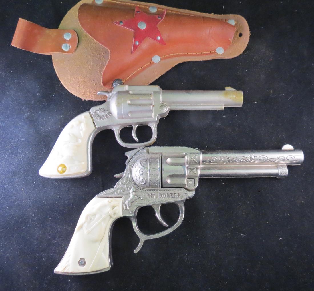 (2) 1950s Western Metal Toy Cap Guns: Includes Hi Ranger and Roy Rogers Models. The Hi Ranger gun works fine. The Roy Rogers gun works fine when you pull the trigger, but you have to manually reset the trigger afterward. Also, the back of