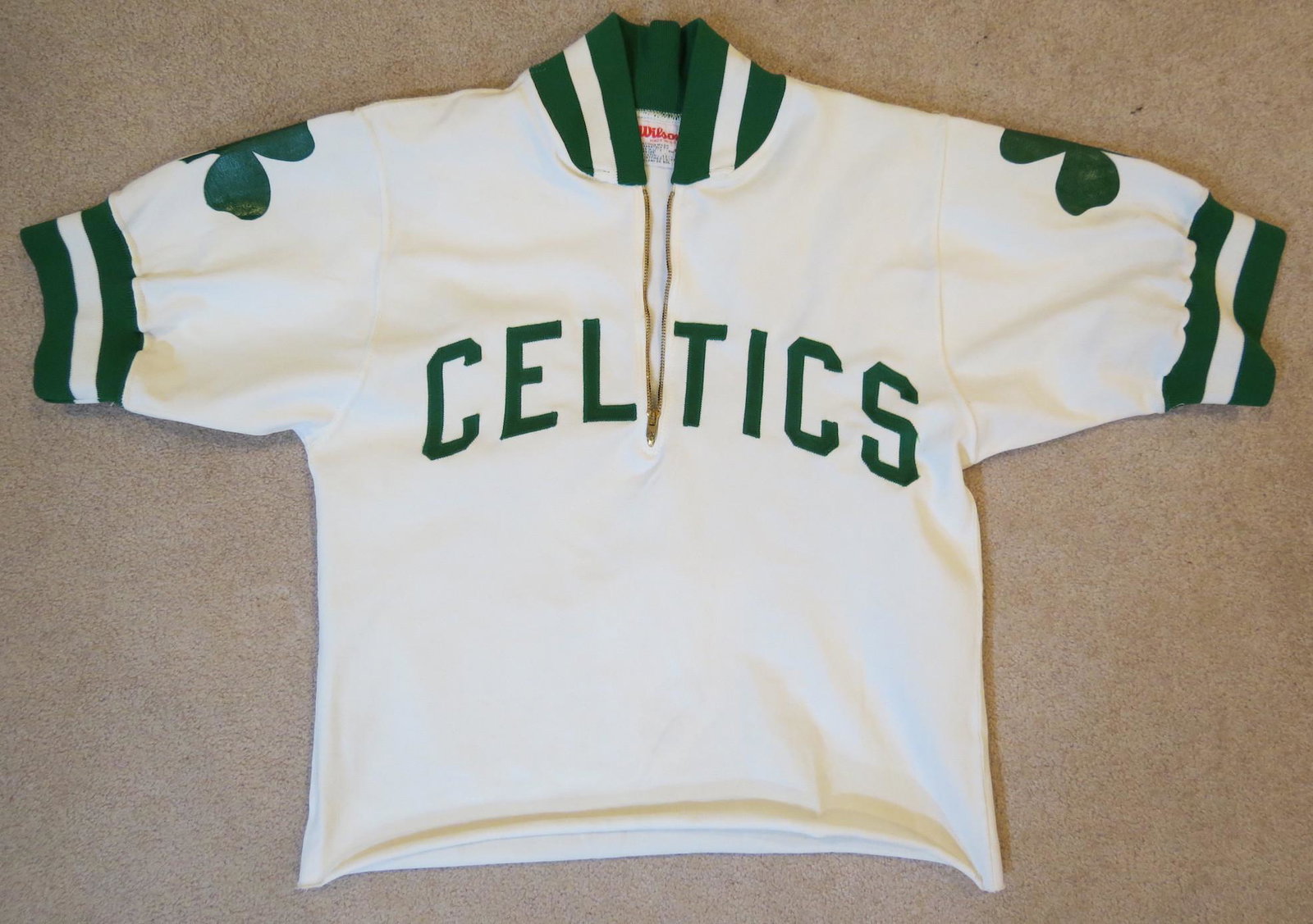 Vintage Boston Celtics Basketball Warm Up Jacket: 1960s-1970s era. Wilson Size 36 tag in the collar. Celtics letters are sewn on, the clovers on the shoulders are silk screened. The jacket has been trimmed along the bottom. 25 inches from the collar 