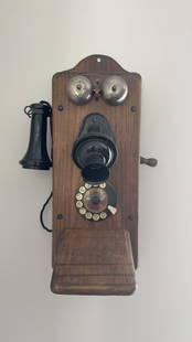 Vintage wooden wall-mounted rotary telephone: Beautifully preserved vintage wooden wall-mounted rotary telephone, a nostalgic relic echoing the elegance and charm of early 20th-century communication devices. Crafted with a robust wood case, this