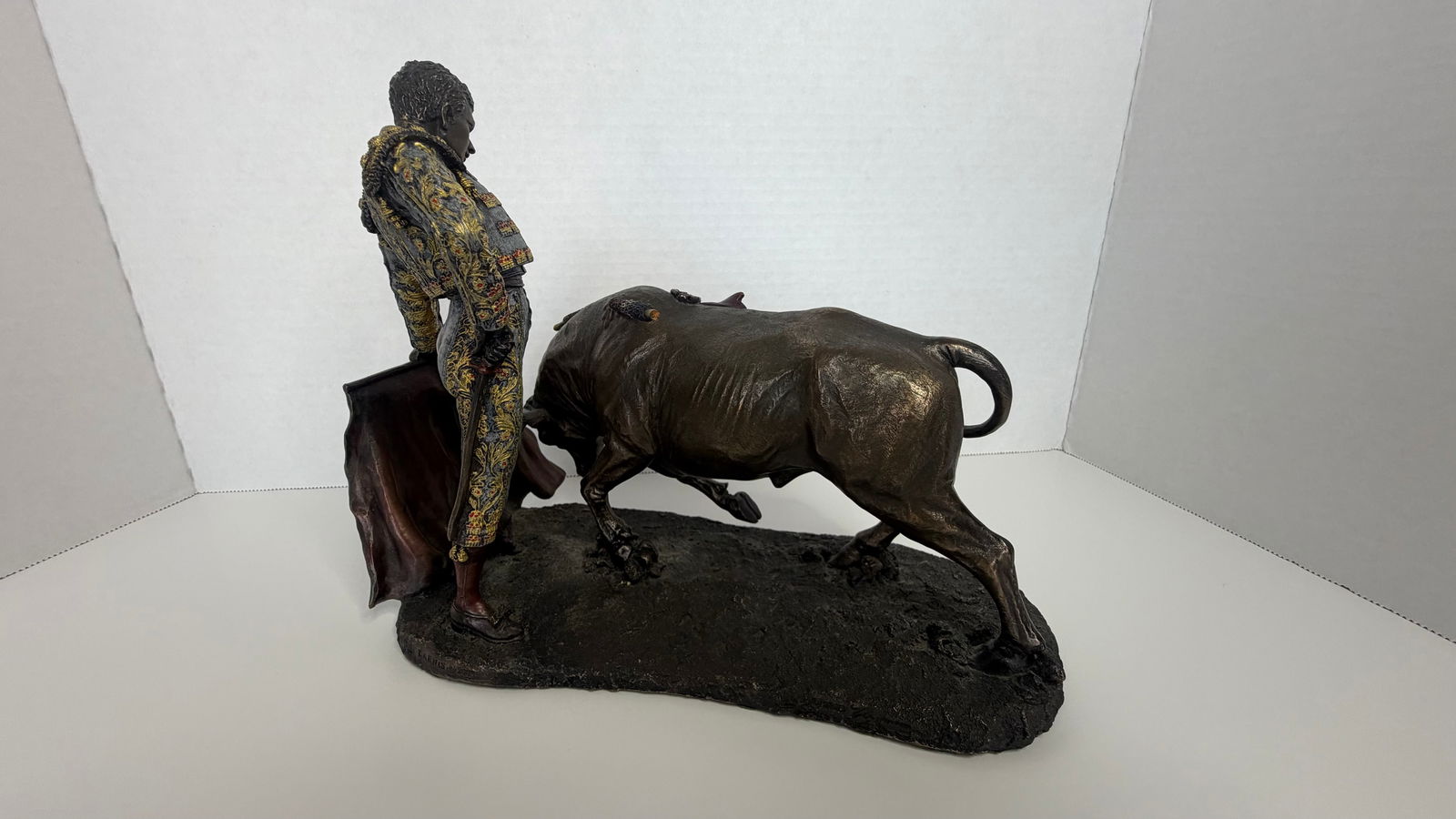 Bronze-Finish Sculpture: Matador and Bull in Mid-Pass: A dynamic and finely detailed sculpture capturing the intensity of the Spanish corrida, this piece features a matador mid-pass, performing a classic vernica with dramatic flourish. The charging bull,