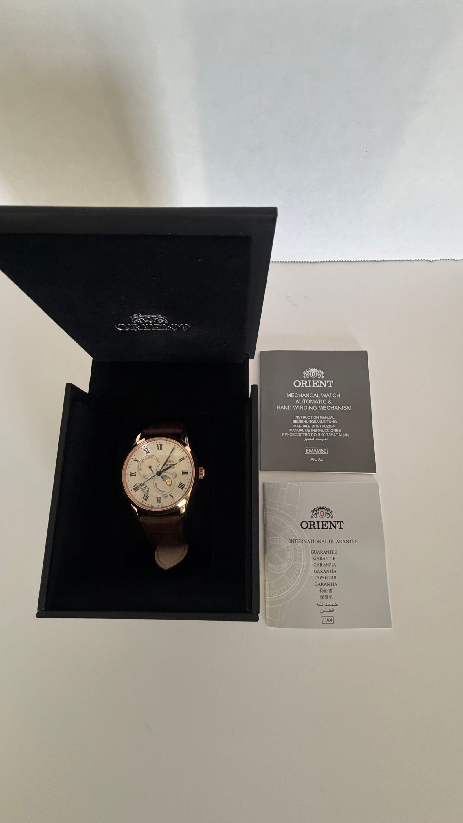 Orient Sun & Moon Automatic Watch – Rose Gold Case, Moonphase Dial, Leather Strap: A sophisticated blend of tradition and artistry, this Orient automatic timepiece embodies classic elegance with a modern twist. Encased in a warm rose gold-tone stainless steel case, the watch feature