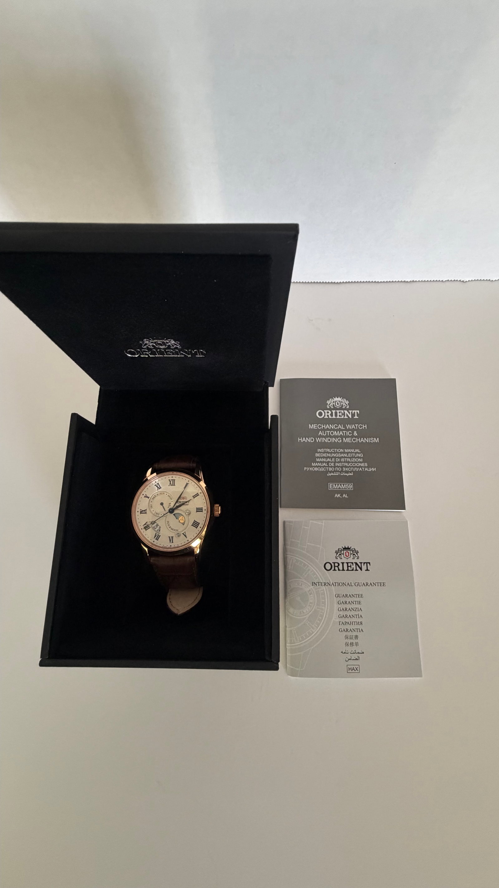 Orient Sun & Moon Automatic Watch – Rose Gold Case, Moonphase Dial, Leather Strap: A sophisticated blend of tradition and artistry, this Orient automatic timepiece embodies classic elegance with a modern twist. Encased in a warm rose gold-tone stainless steel case, the watch
