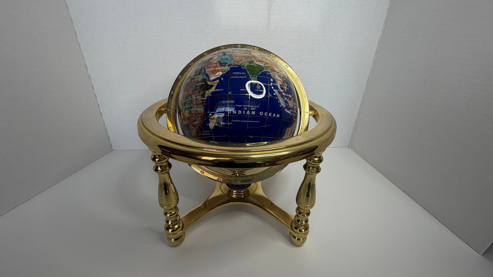 Brazilian Semi-Precious Gemstone Globe in Gold-Tone Armillary Stand: A luxurious and meticulously handcrafted gemstone globe, set within a gold-tone armillary-style stand, fusing artistry, geography, and refined decor. This striking display piece features continents in