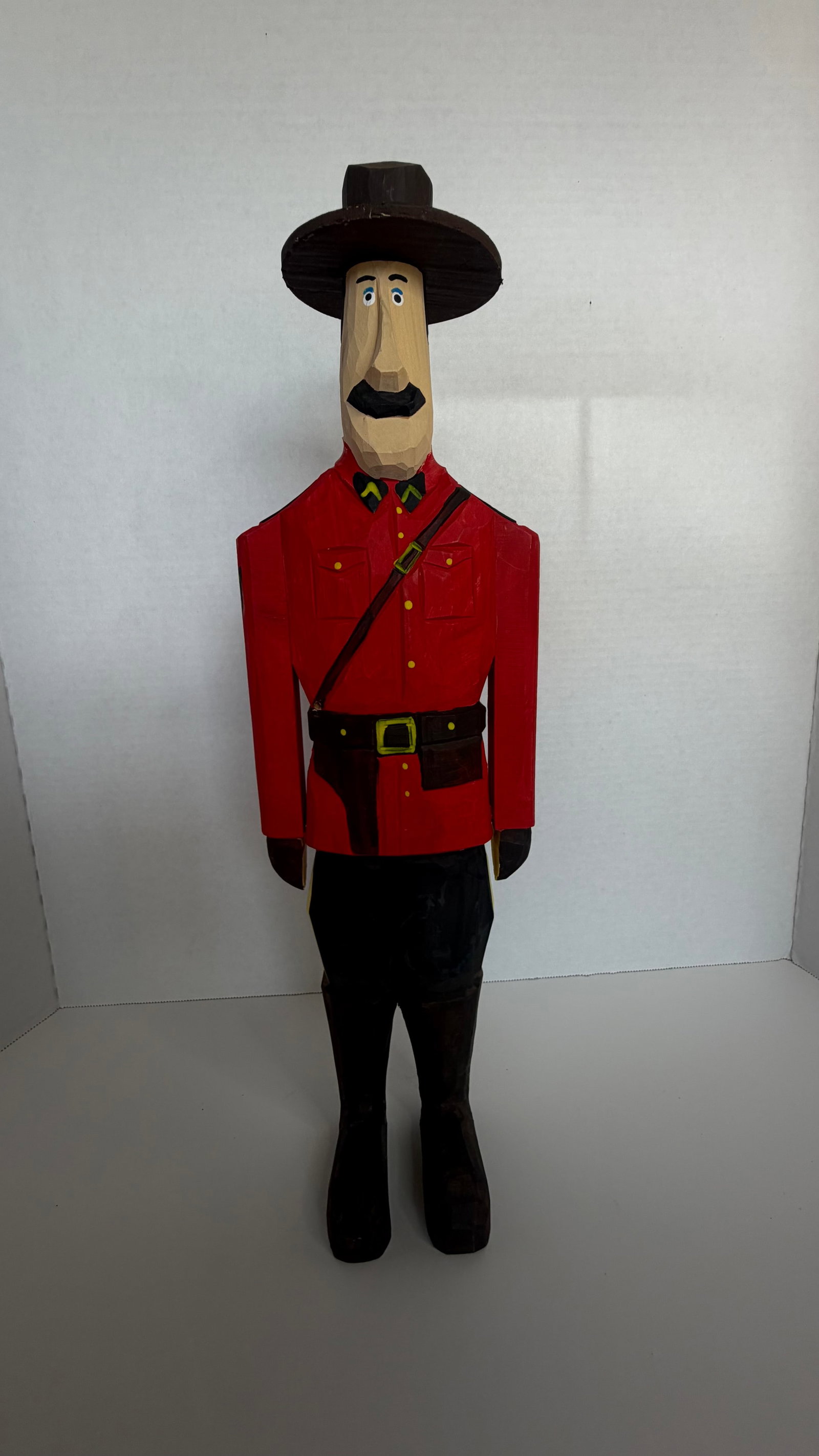 Folk Art Woodcarving of Royal Canadian Mounted Police Officer (“Mountie”): A delightful and character-rich example of North American folk woodcarving, this tall, hand-carved wooden figure represents a Royal Canadian Mounted Police officer, affectionately rendered with