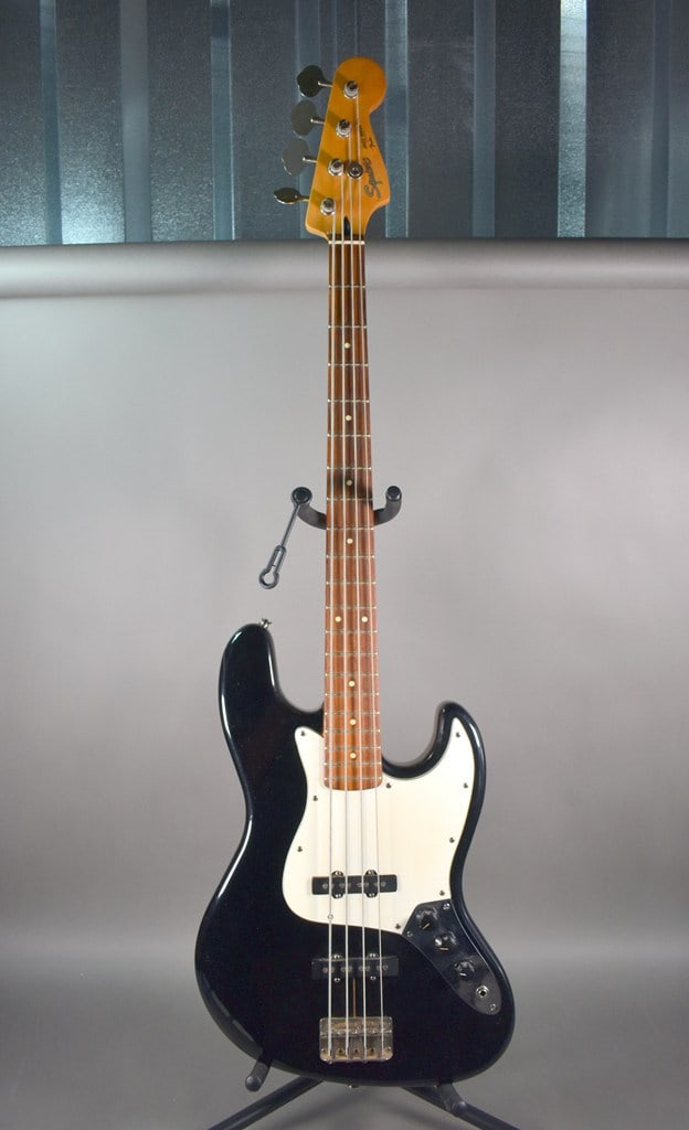 1987–1988 “E-Series" Squier by Fender Jazz Bass Guitar in Black Finish with Hard Case: Very good cosmetic condition. Something about the output jack is loose—possibly a loose connection inside. I have not tried to fix it as that is beond the scope of my job. When you put side pres
