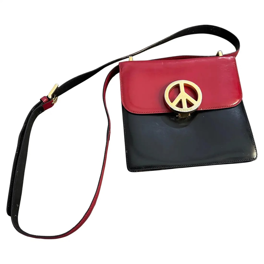 A 1980s Iconic Franco Moschino Small Hand Bag: This 1980s vintage handbag is an iconic design by Franco Moschino. It reflects the playful and bold aesthetic Moschino is known for. The handbag features a striking combination of blue and red patent