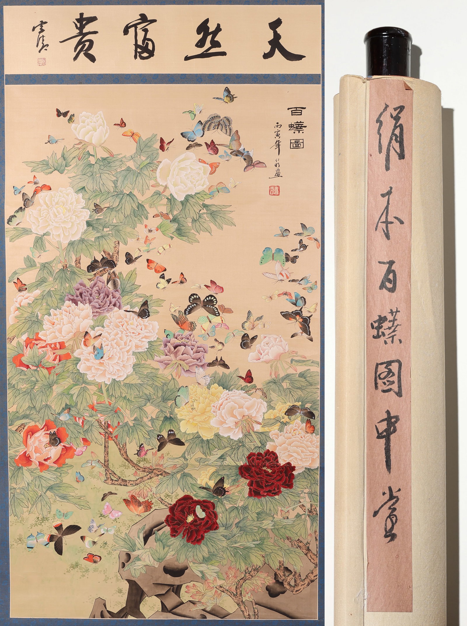 "One Hundred Butterflies" Scroll Painting: Chinese (20th c.) "One Hundred Butterflies" Hanging Scroll Painting on Silk, a vibrant depiction of butterflies among blooming flowers including peonies with a calligraphy panel at the top of the scro