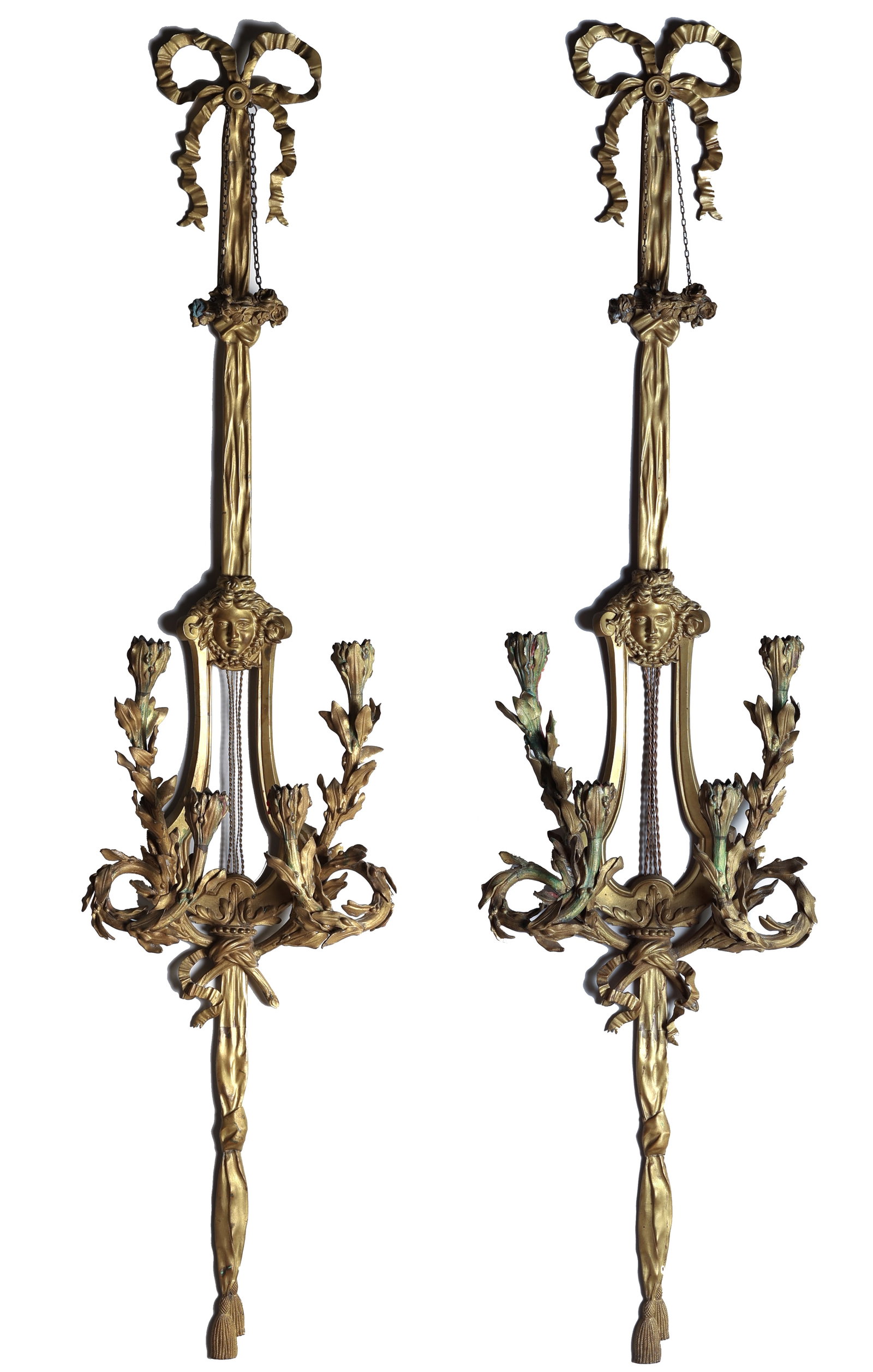 Pair of Gilt Bronze Sconces after Dasson: Pair of French Louis XVI Style Parisian Gilt-Bronze Wall Sconces, After Henry Dasson. Each with a lyre-shaped backplate surmounted by a mask of Mercury, ribbon-tied flowering branches and tassels, sus