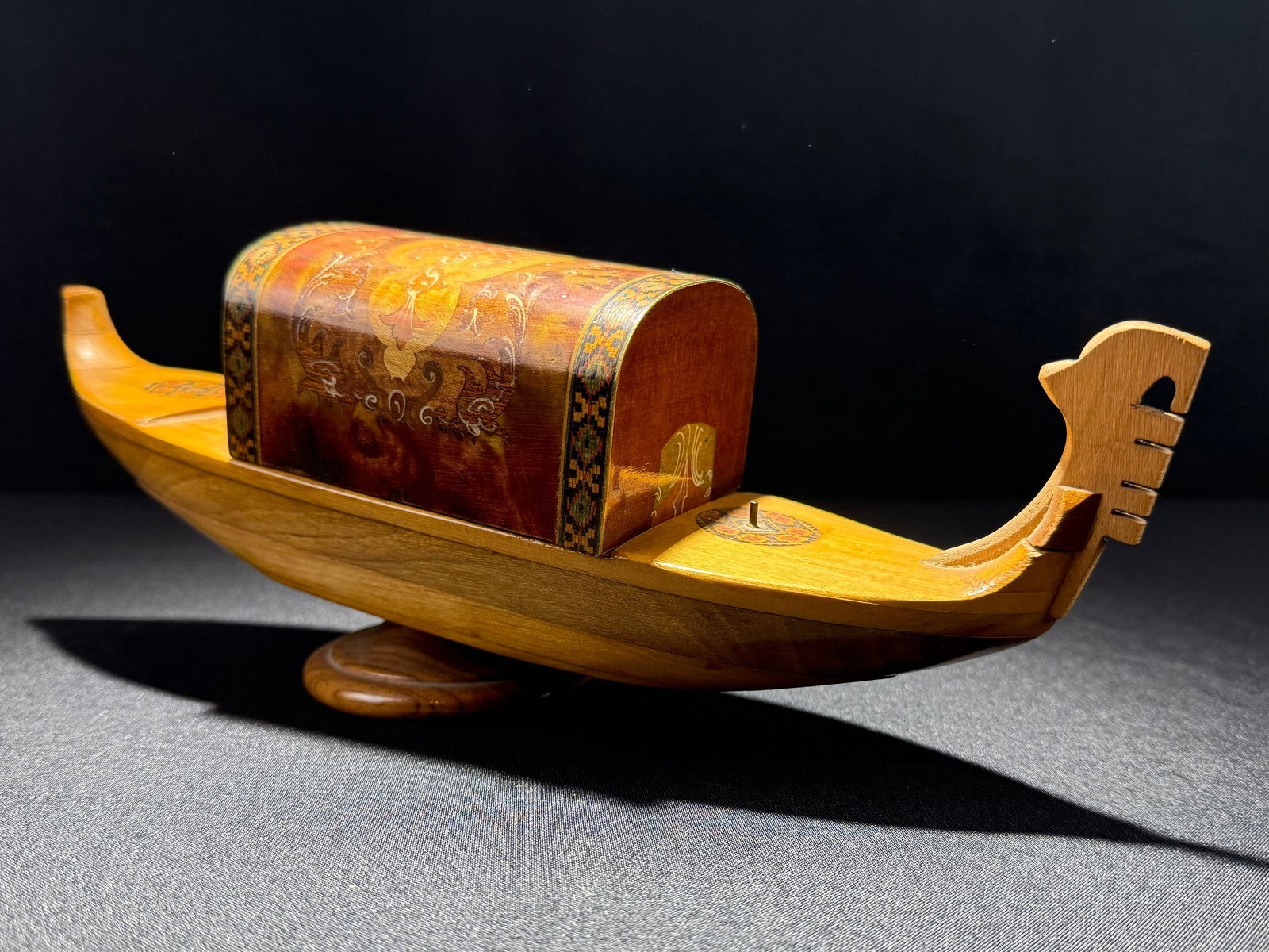 LADOR "Rhapsodie Suedoise" Wooden Decorative Gondola Cigarette Box, Early-Mid 20th Century: Exquisite handcrafted wooden gondola-form Cigarette Box display piece. The box showcases intricate scrollwork designs on a rich brown/copper-toned finish, bordered by detailed geometric patterned band