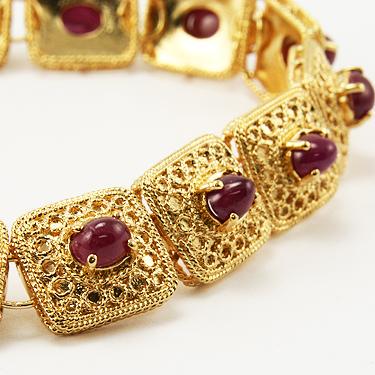 7 CT Cabochon Ruby Gold Bracelet: Master jewelers designed your bracelet with 14 pieces of GENUINE 5X4mm faceted oval cabochon rubies. 24 grams of brass layered with 18K gold. The length is 7 1/2 inches or 190mm. The width is 1/2 inch