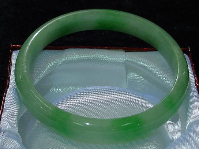 Hand Crafted Burmese Jadeite Round Bracelet: is bracelet is made from one solid piece of BURMESE JADEITE. All natural color. It appears light green with some spots dark green. It is transparent. Wearing jade bracelet is believed to improve your 