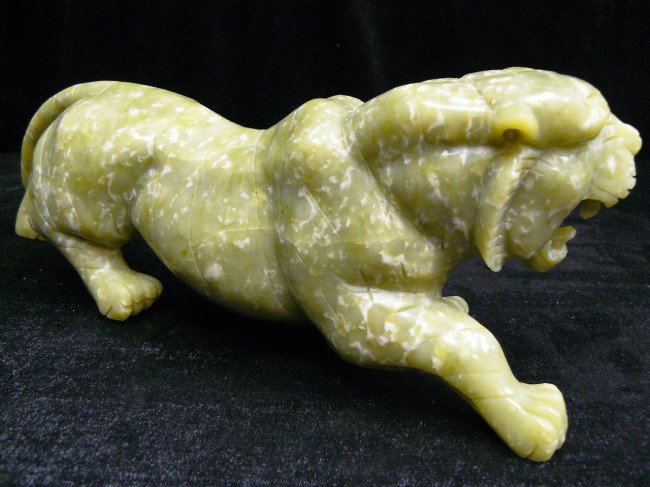 Hand Crafted Natural Jade Tiger: This jade tiger is made from one solid piece of Jade. It appears light green with some spots dark green. All hand carved from natural jade. Size: Wide: 12", Deep: 3", High: 4"