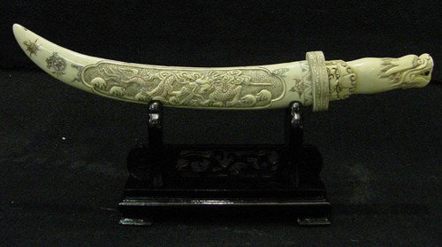 Antique Natural Cow Bone Dragon Sword Set: This sword set is made of cow Bone. It has been specially stained and painted. There is a dragon carved in the front. It sits on a rosewood stand. The sword blade is also made of bone. Very detailed c