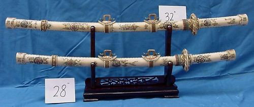 Antique Bone Japanese Sword Set: This sword set is made of cow bones. It has been specially stained and painted. There is a dragon carved in the front. It sits on a rosewood stand. The sword blade is also made of bone. The upper shor