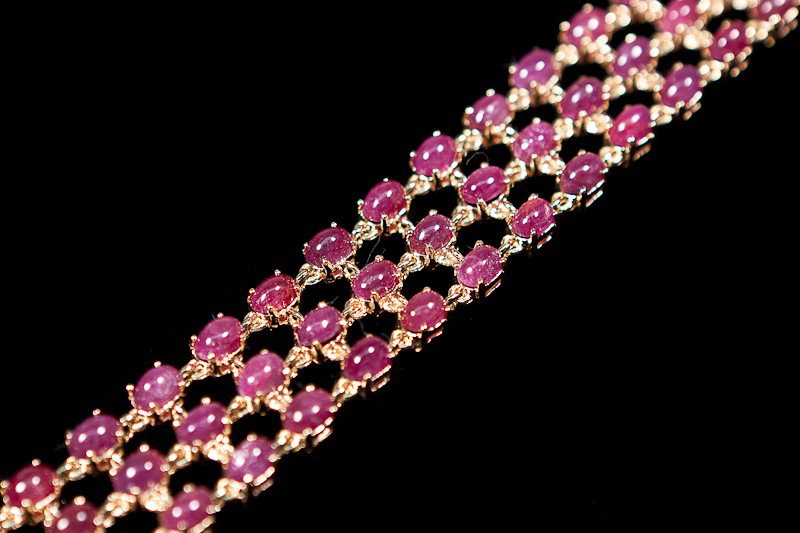 Genuine 40 CT Cabochon Ruby 3 Row Bracelet: Master jewelers designed your bracelet with 66 pieces of GENUINE 6X4mm faceted oval cabochon Ruby. 29.6 grams of sterling silver layered with 18K Gold. The length is 7 1/2 inches The width is 3/4 inch