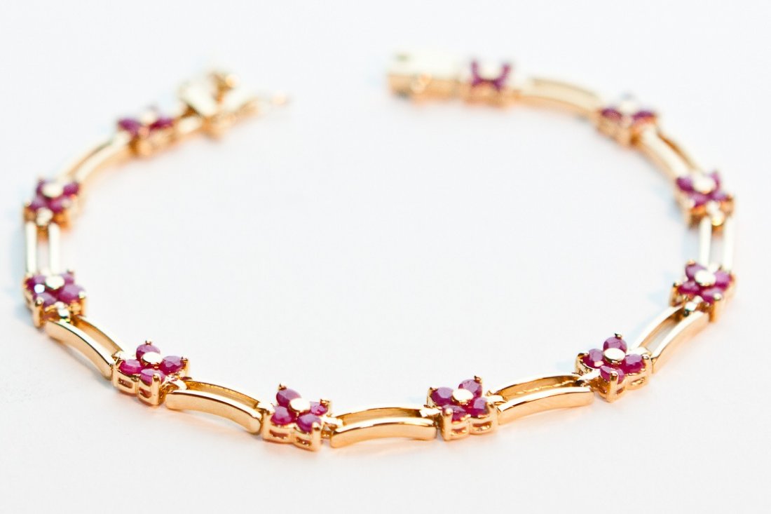 Genuine 11 CT Cabochon Ruby Floral Bracelet: Master jewelers designed your bracelet with 44 pieces of GENUINE faceted cabochon rubies. 17 grams of sterling silver layered with 18K Gold. The length is inch The width is 1/4 inches or 6mm