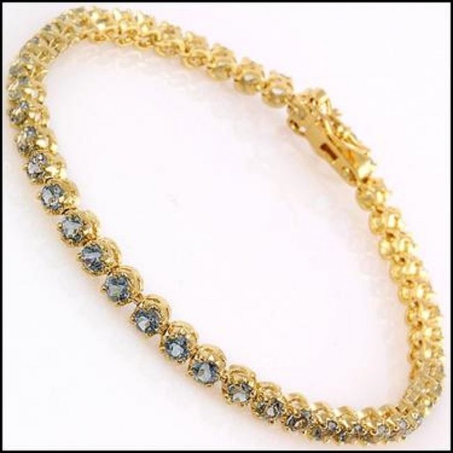 10.22 CT Blue Topaz Tennis Fine Bracelet $1120: Master jewelers designed your bracelet with: 45 pieces of GENUINE 4mm faceted Topaz quality AAA no treatment. 12.12 grams of Base Metal layered with 18K yellow gold (18KGP). The length is around 7 1/2