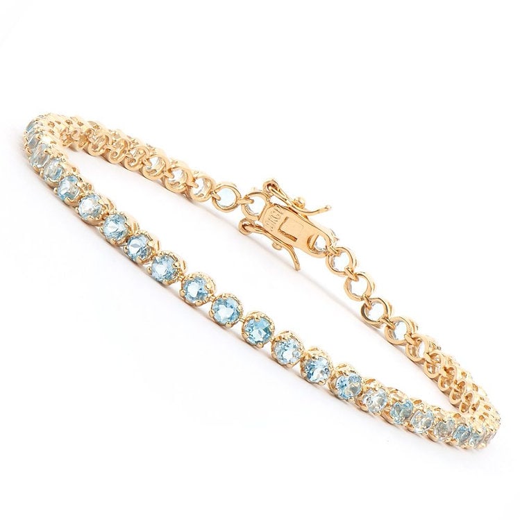 10.22 CT Blue Topaz Tennis Fine Bracelet $1120: Master jewelers designed your bracelet with: 45 pieces of GENUINE 4mm faceted Topaz quality AAA no treatment. 12.12 grams of Base Metal layered with 18K yellow gold (18KGP). The length is around 7 1/2