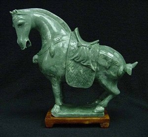 REAL JADE SADDLED TANG HORSE: This horse is made from one piece solid Taiwan jade. It appears light green with some area dark green. It comes with a wooden base. L: 7", W: 3", H: 6"